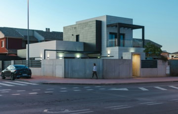 a man walking across a street in front of a building